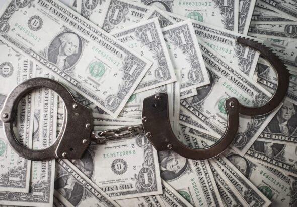 closeup-shot-metal-handcuffs-dollars